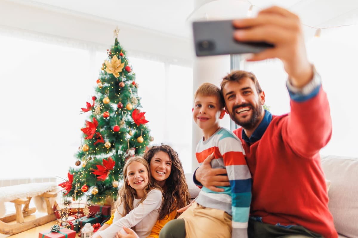 happy-family-taking-selfies-by-the-christmas-tree